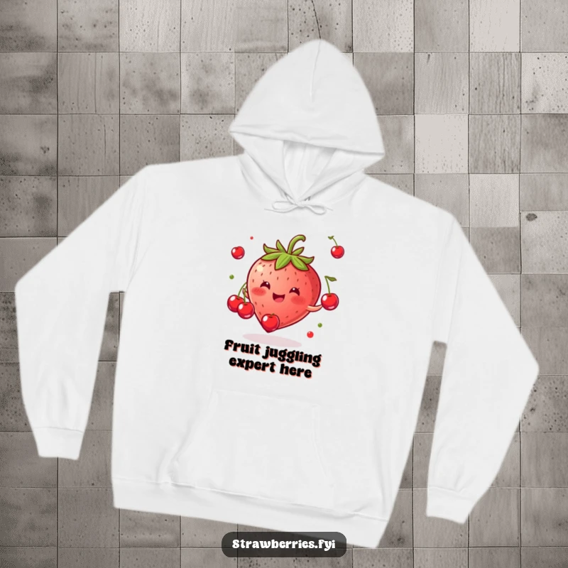 Funny hoodie showing a happy strawberry performing a fun juggling act with tiny cherries, radiating pure glee.